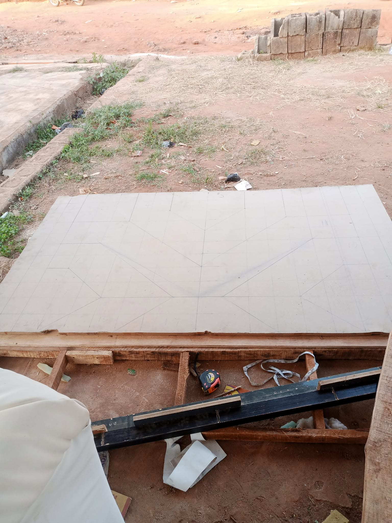 Large board marked with a full-scale geometric layout for a custom bed headboard