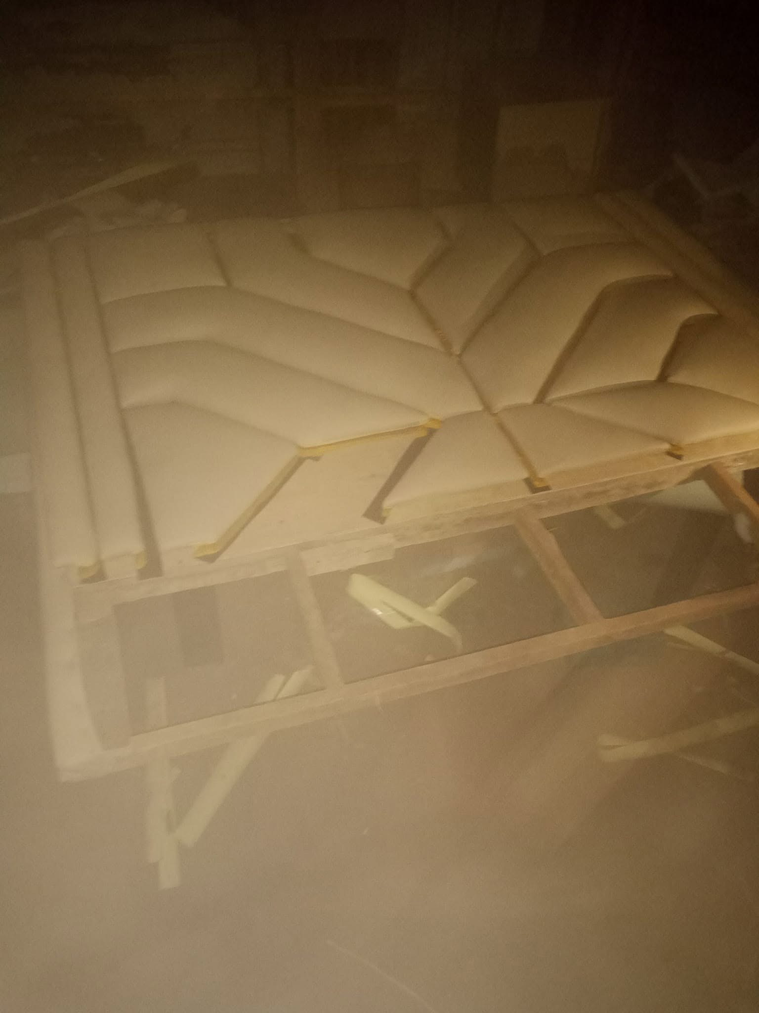 Upholstered custom bed headboard components arranged on a workbench before final assembly
