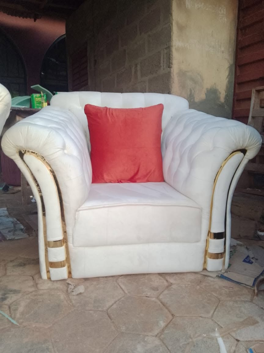Detail view of a white and gold upholstered armchair at the workshop
