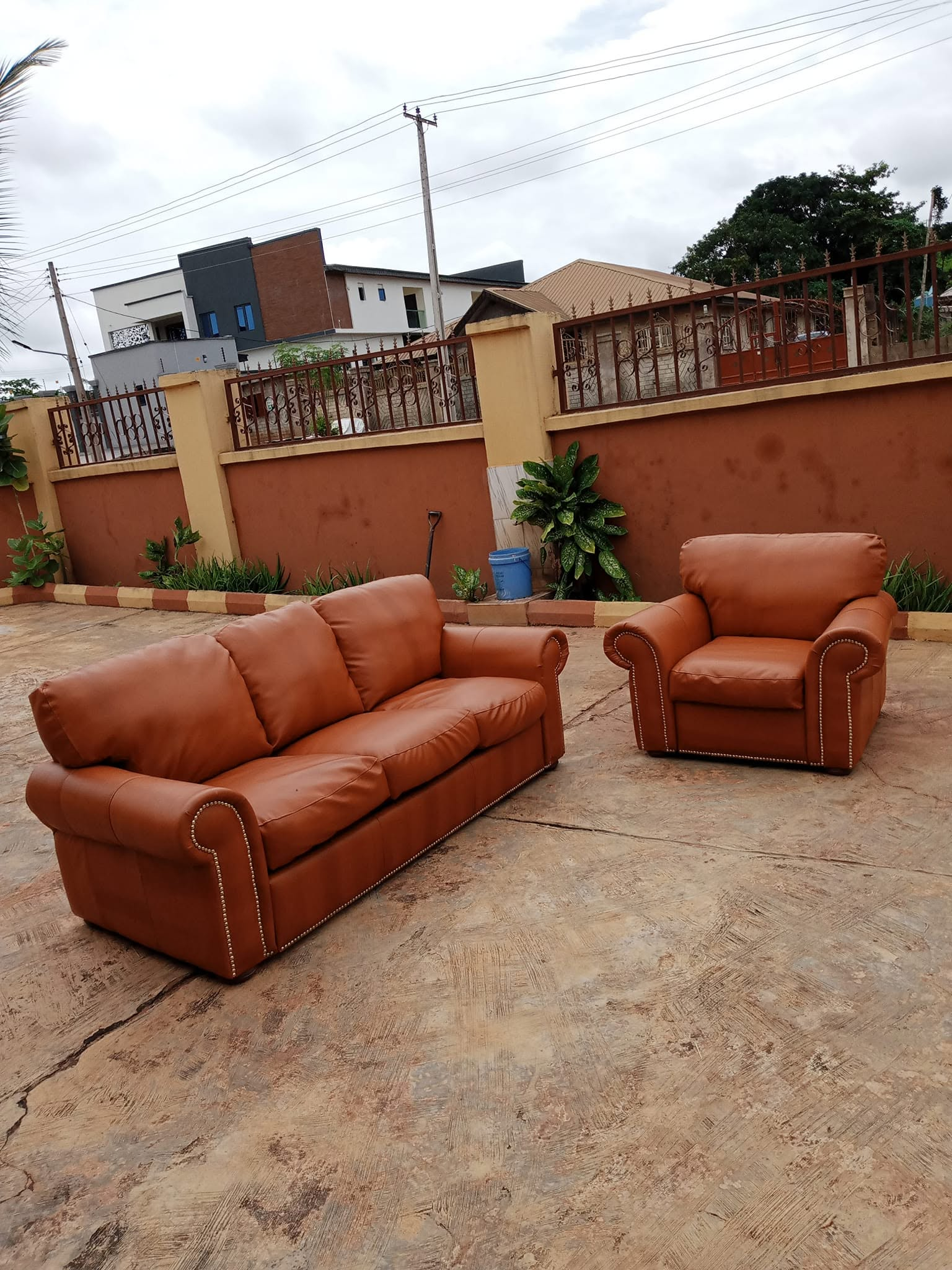 Caramel upholstered sofa and matching armchair photographed together outdoors