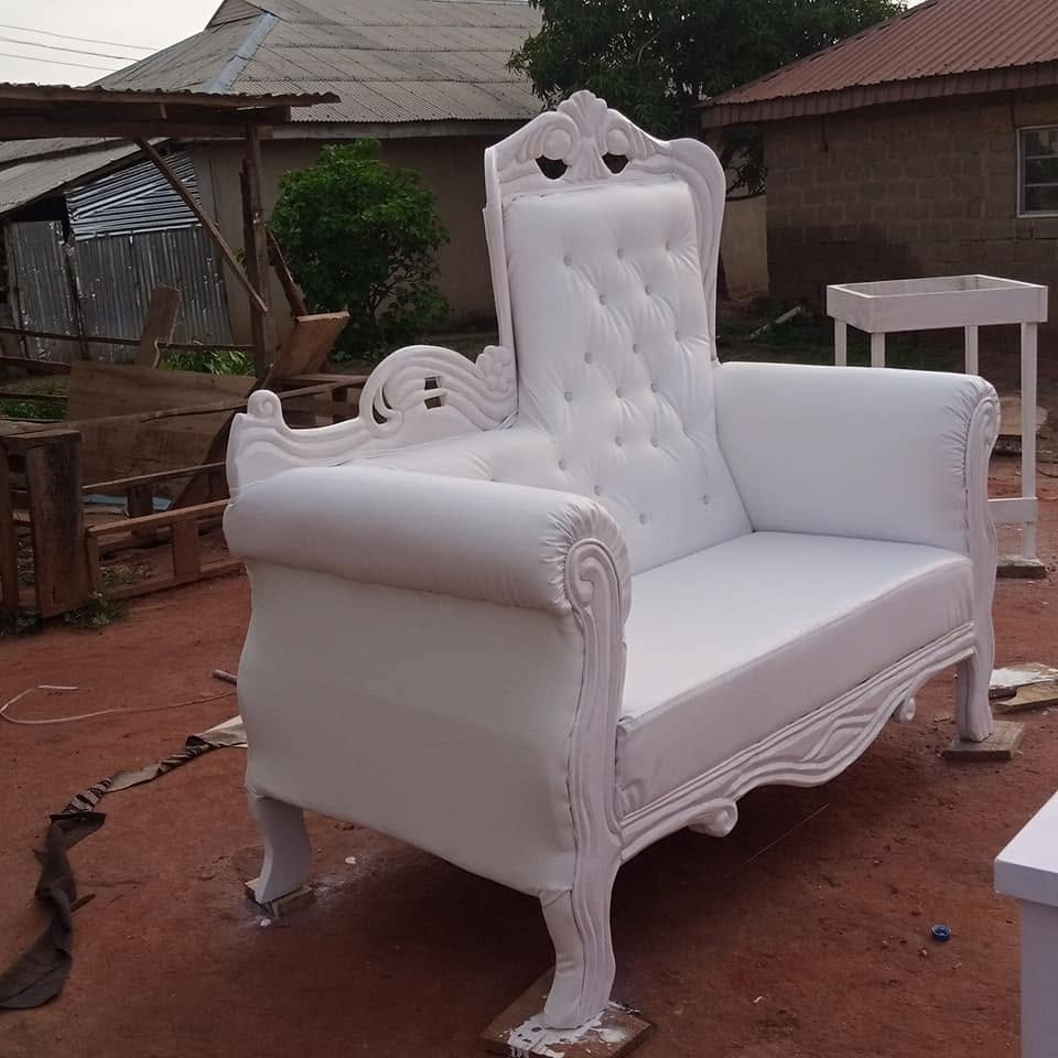 Angled workshop view of a tall white carved button-tufted chair